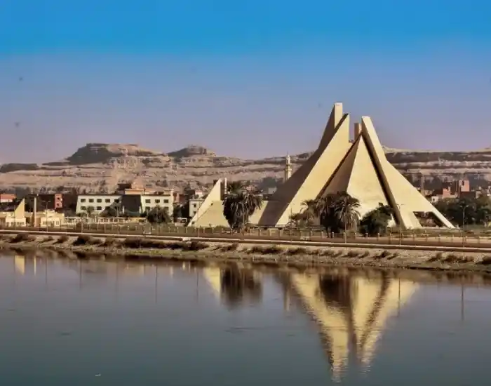 Modern-Pyramid-Shaped-Monument-Reflecting-In-The-Nile-River-In-Minya-EgyptaTours